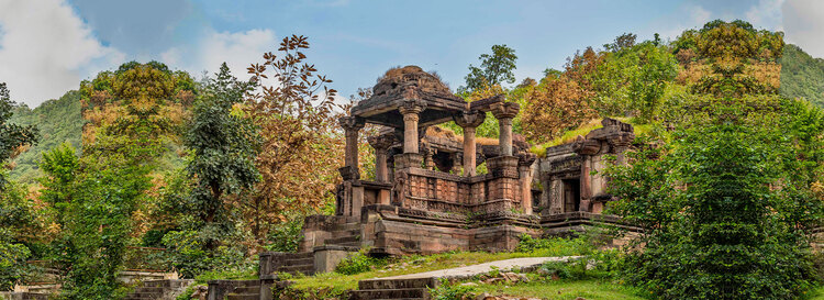 Old monument surrounded by lush greenery