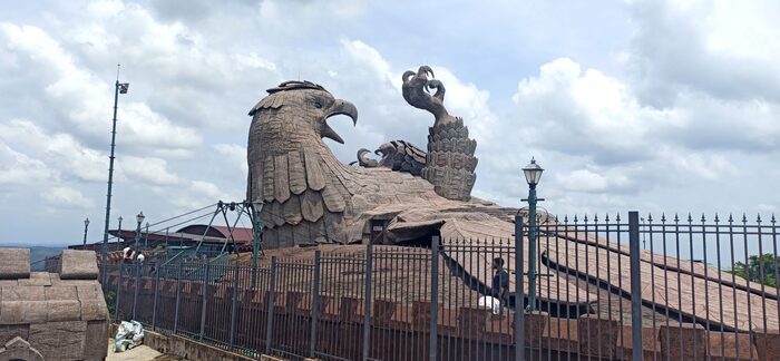 Tourists interacting with the Jatayu Earth Sculpture, emphasizing its scale and popularity as a tourist attraction